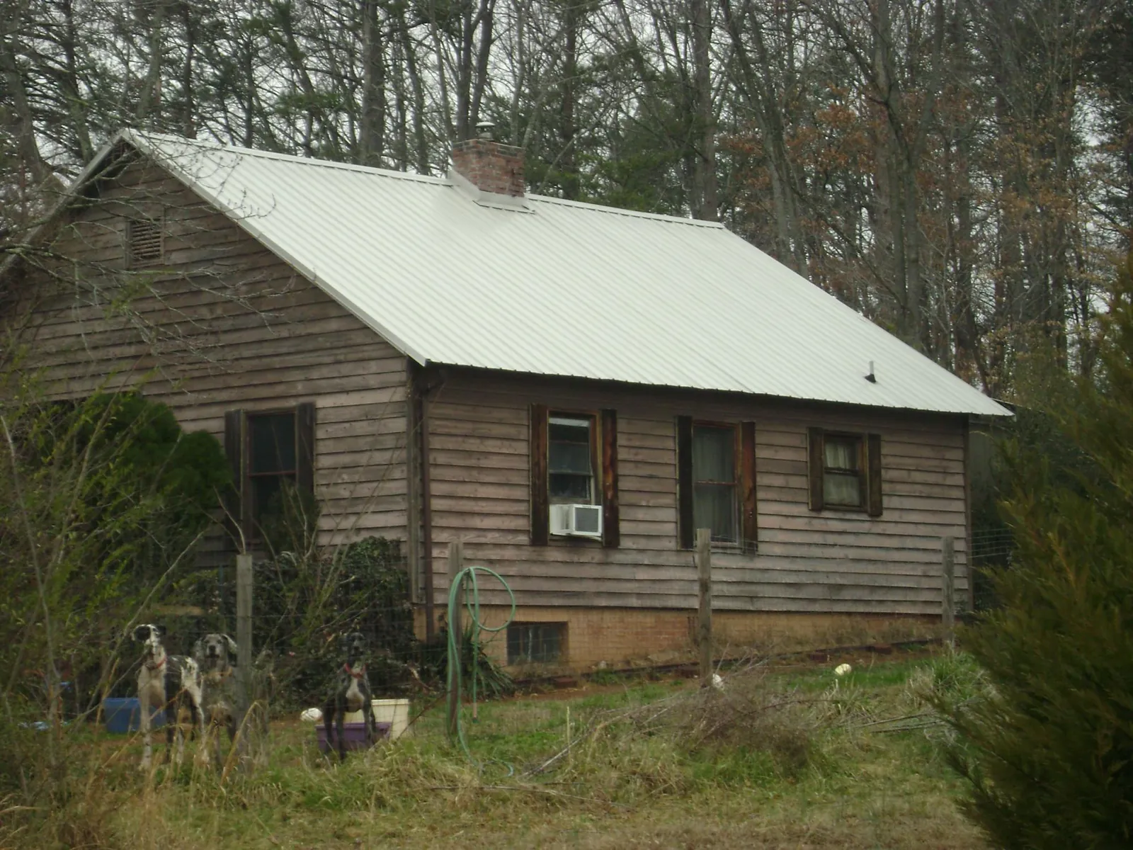 White metal roof on an old wood sided farmhouse, from a Metal Roof Installation job in Aurora